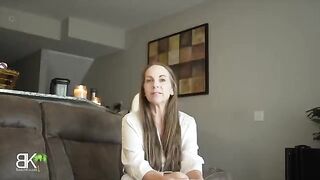A mom shares a couch with her stepson in a taboo roleplay scene