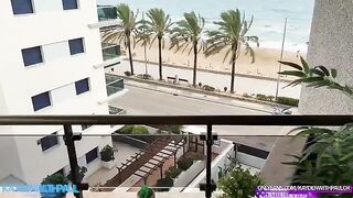 A couple engaged in a passionate encounter on the balcony while the sea view