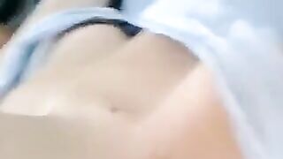 A half-naked girl is lying on the bed and playing with her body