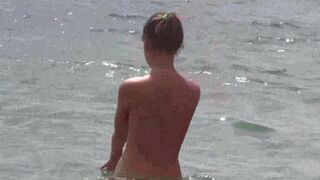 A bunch of naked people are having fun on the beach in HD