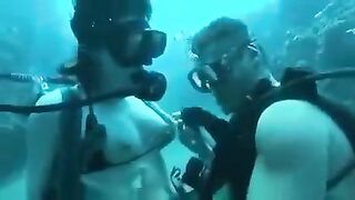 Underwater sex of two aqualangists at the bottom of the sea