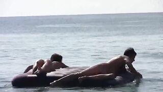 A blonde is getting naked on the sandy bank