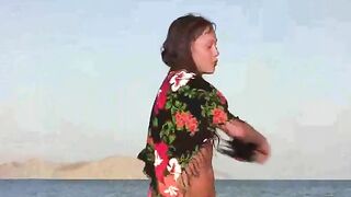 A member shows a naked girl in a compromising pose on the beach