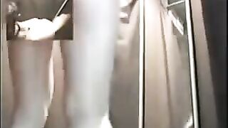 A girl is undressing in the locker room of an underwear store, unaware of a hidden camera