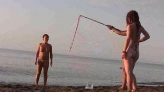 A naked girl is having fun on the beach, exploring her body
