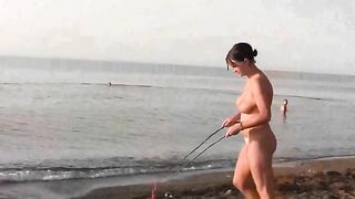 A naked girl is having fun on the beach, exploring her body