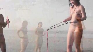 A naked girl is having fun on the beach, exploring her body