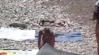 A couple of free-spirited nudists enjoy each other on the beach