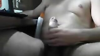 A man masturbates his cock with his hand while sitting in front of the computer