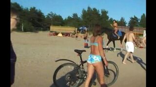 A topless girl is having fun on the beach, showing her body