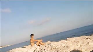 A girl sunbathes naked on the beach, it's a real joy
