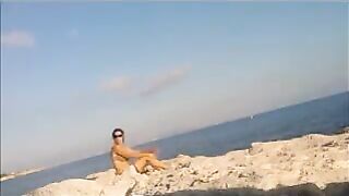 A girl sunbathes naked on the beach, it's a real joy