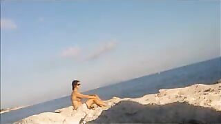 A girl sunbathes naked on the beach, it's a real joy