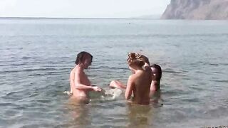 A bunch of naked people on the beach, enjoying themselves